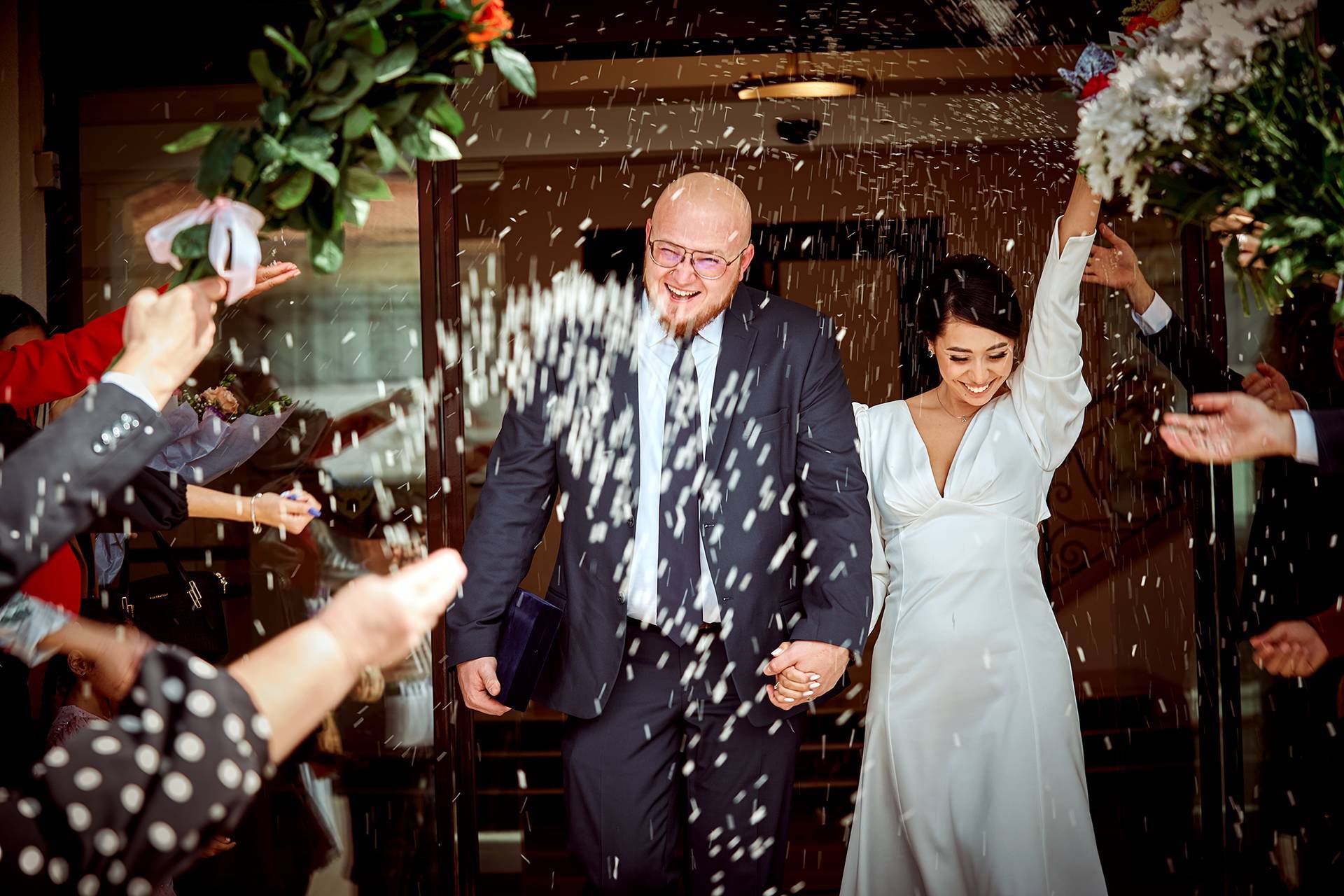 Ieșire plină de bucurie – fotograf nuntă Transilvania Mirii ies de la cununia civilă, în timp ce invitații aruncă orez, plini de bucurie și entuziasm