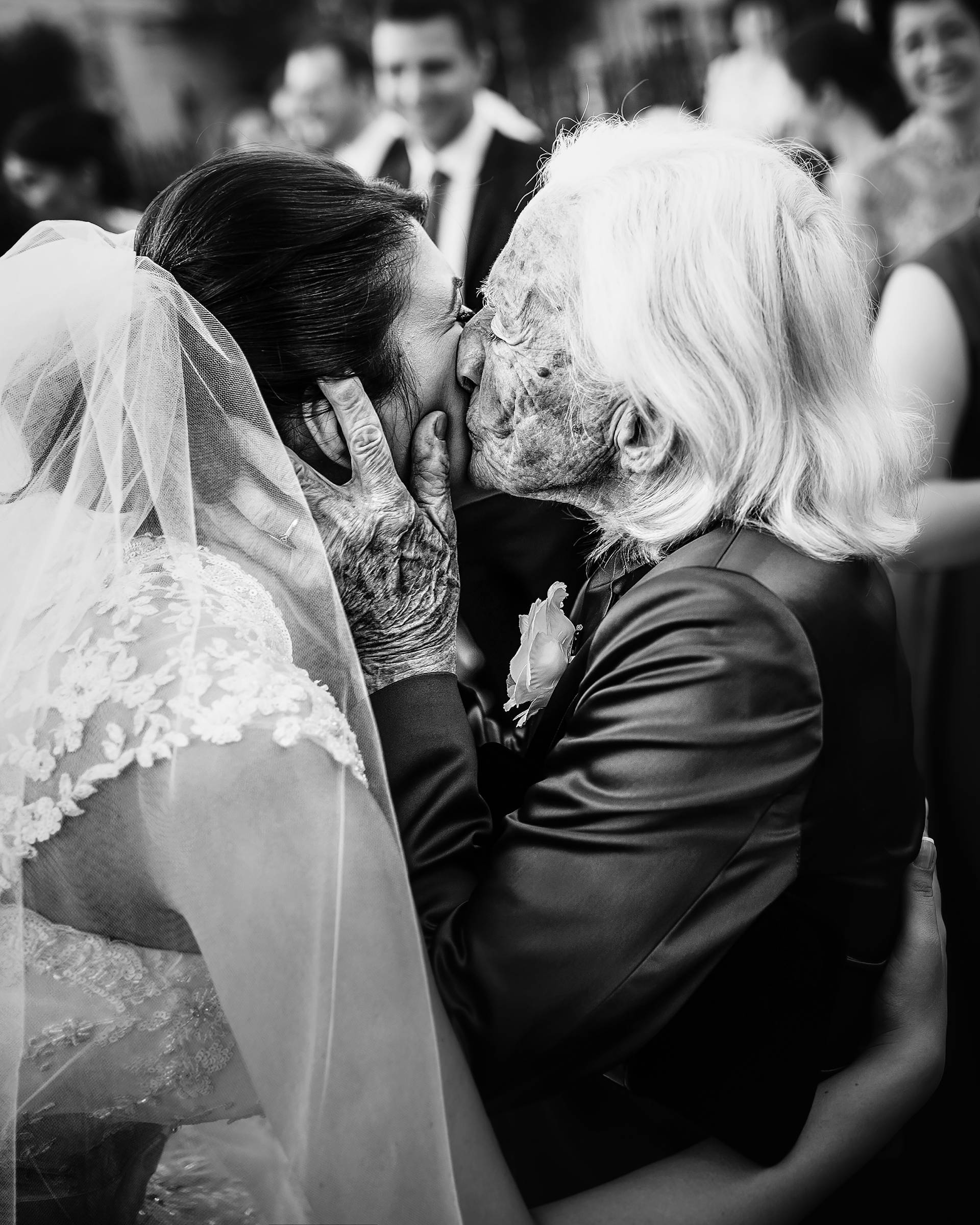 Sărutul plin de emoție – fotograf nuntă Transilvania Doamnă în vârstă sărută mireasa pe obraz – un moment plin de emoție la nunta din Transilvania