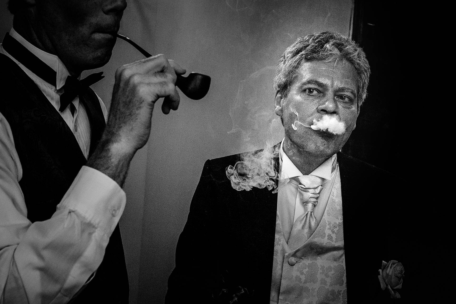 Invitați la nuntă – fotograf nuntă Transilvania Fumul trabucului se ridică ca o perdea peste fața invitatului – un moment autentic de la nuntă